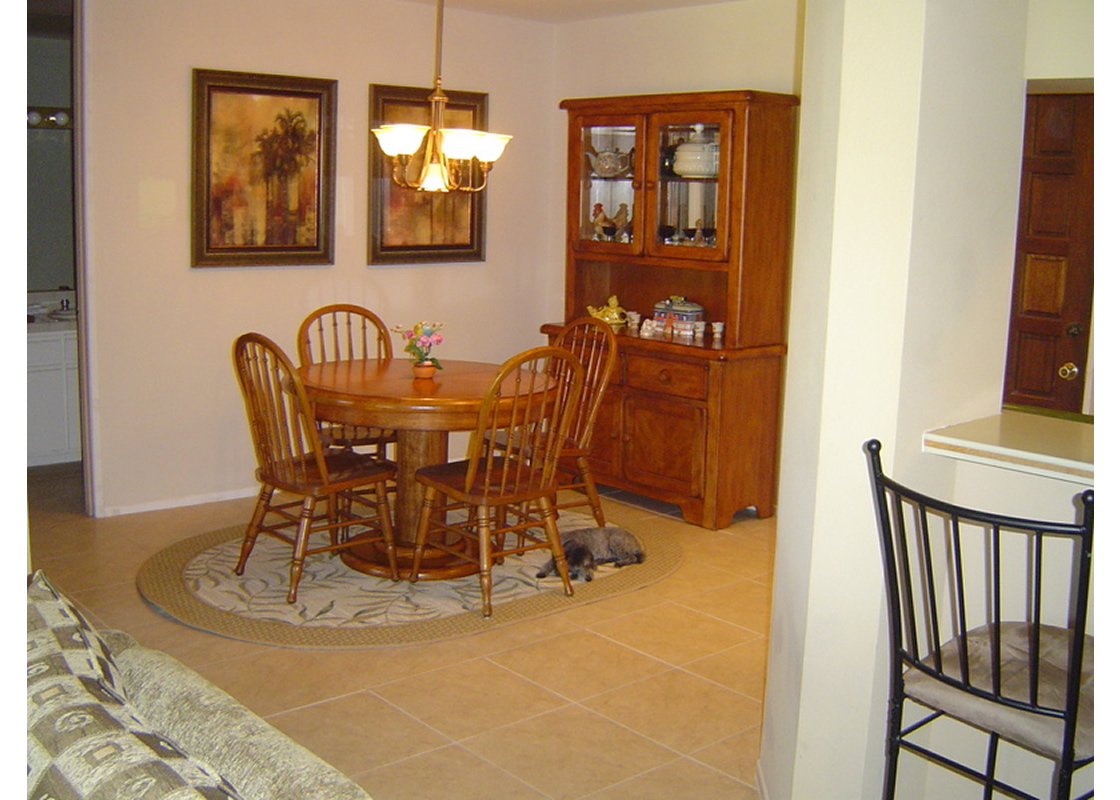 The new dining room, with a small table, four chairs, and a set of cabinets/shelves
