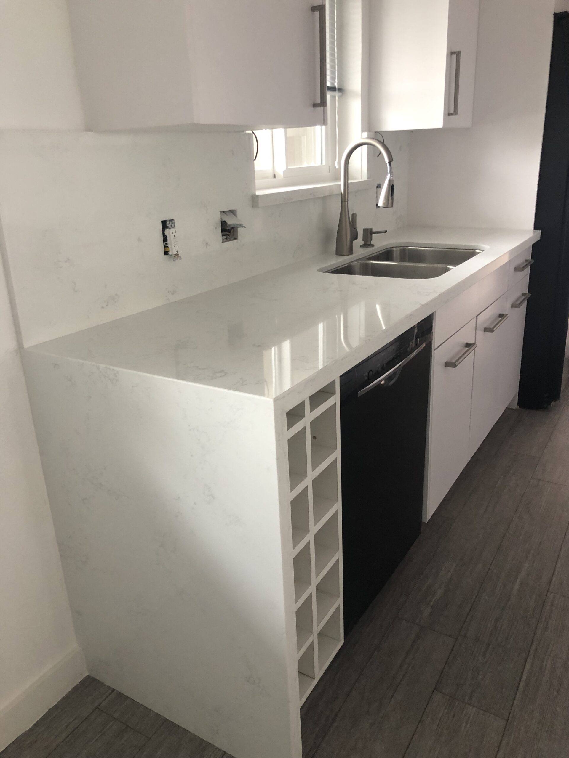 A picture of a kitchen sink, with some cabinets beneath it.