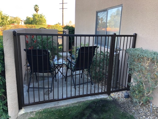 A picture of a metal fence enclosing a small patio